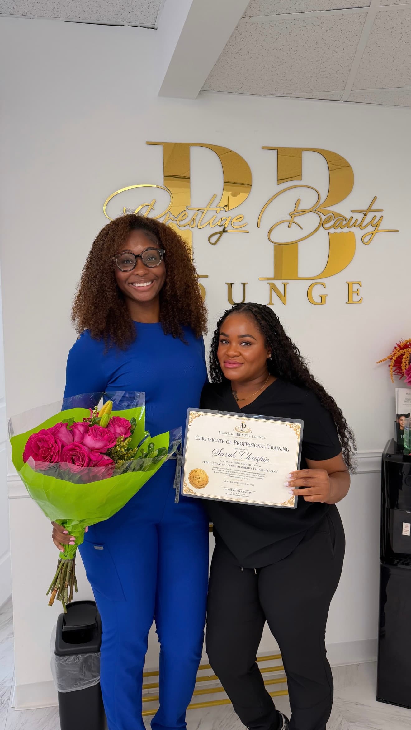 Jennifer Myers with graduate Sarah Chrispin holding flowers and her Certificate of Professional Training